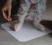 Checking baby foot size mother holding leg of her child on the blank paper drawing around with pencil to measure feet size family concept close up